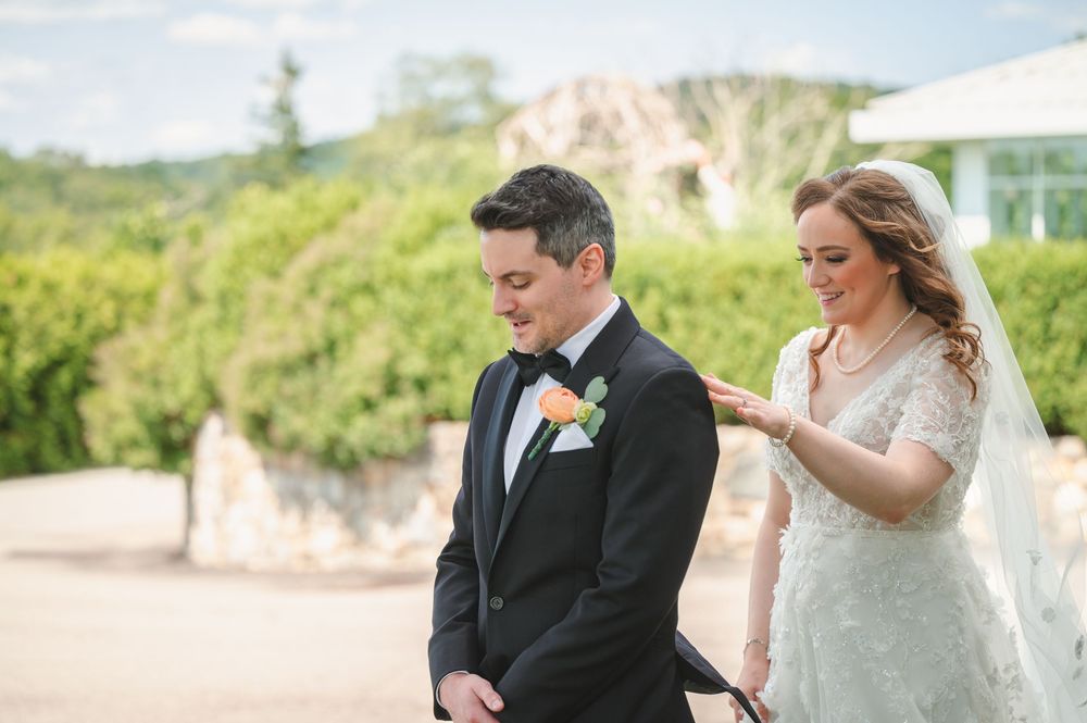 A couple sharing a special moment outdoors during their wedding ceremony on a sunny day.
