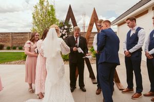 A series of wedding ceremony moments showing bridal party members in navy blue and blush pink attire at an outdoor venue.