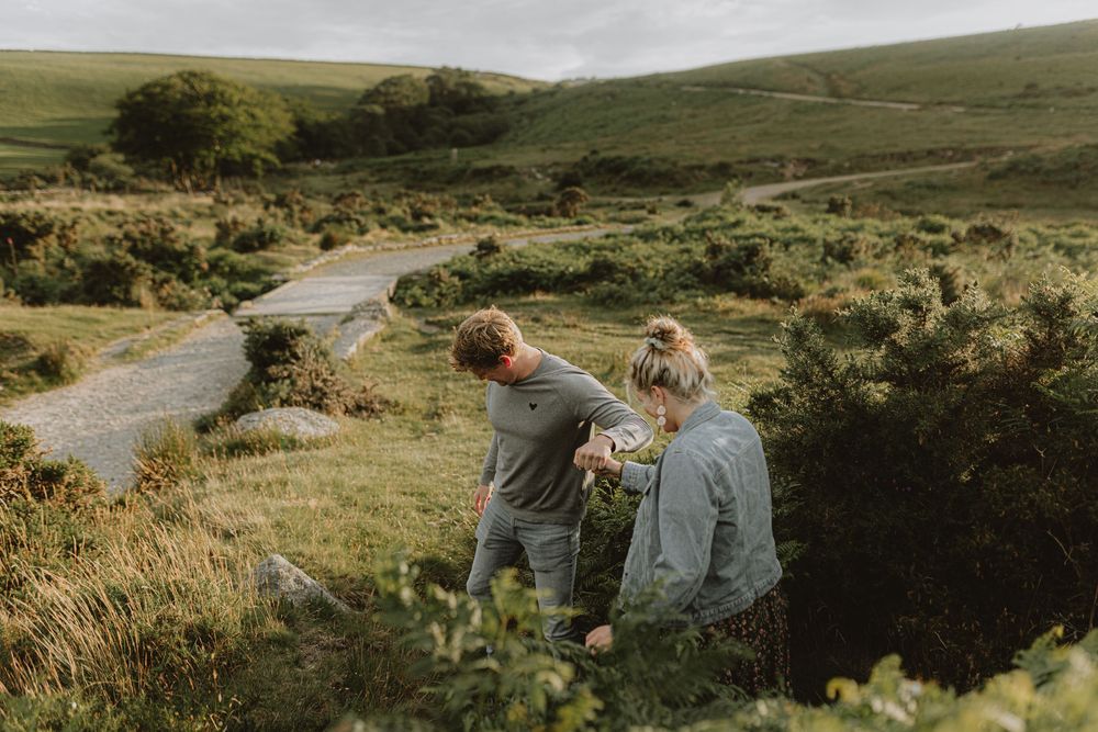 A panoramic view of rolling hills with a couple walking along a winding path.