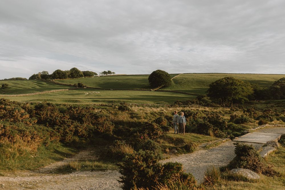 A scenic landscape view of green rolling hills and winding roads under cloudy skies.
