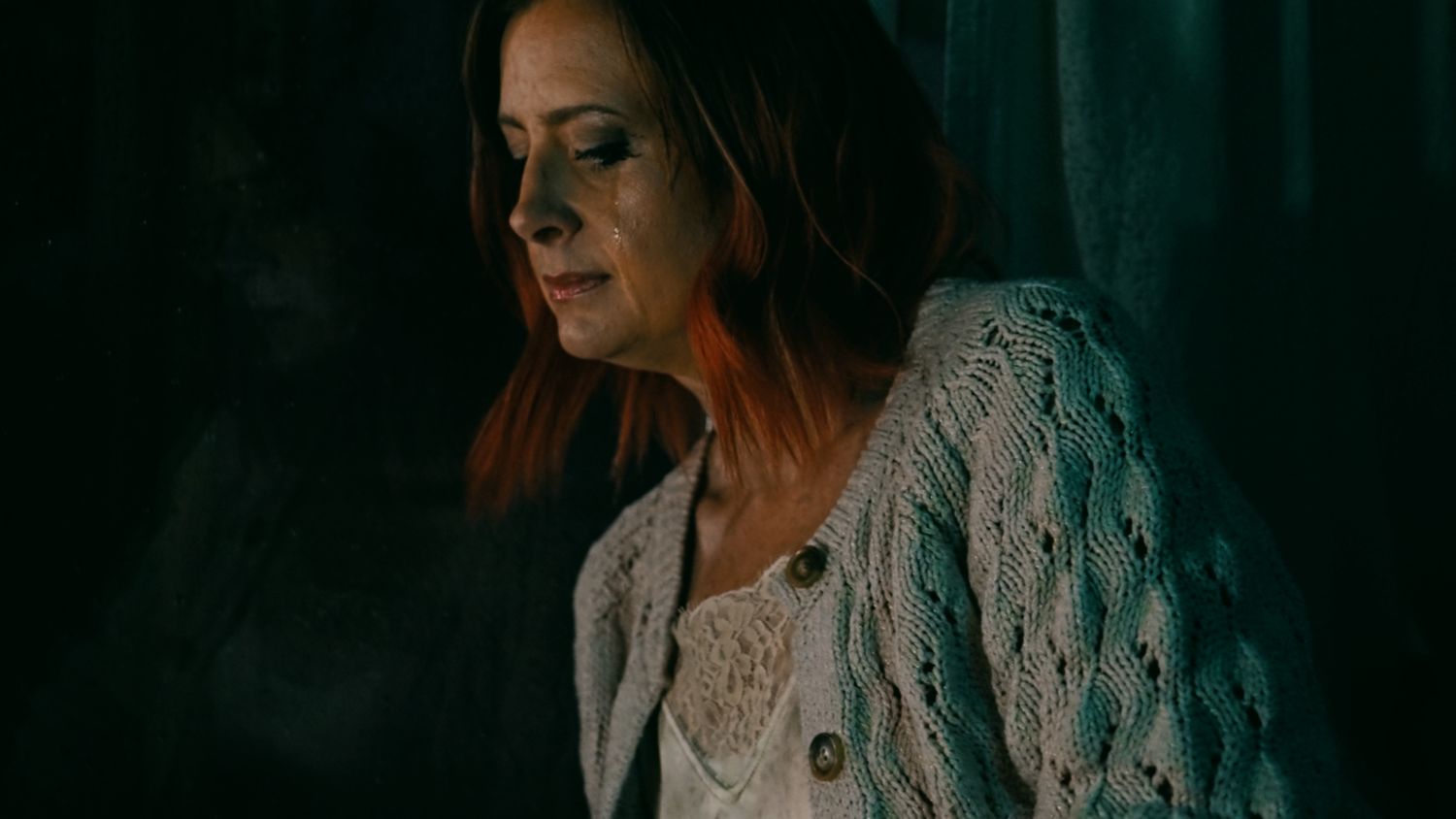 Dramatic portrait in moody lighting showcasing intricate lace details.