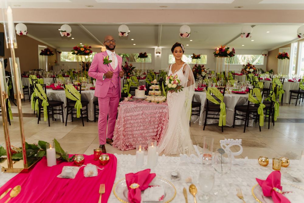 Elegant wedding reception venue with white linens and pink accents set up for a celebration.