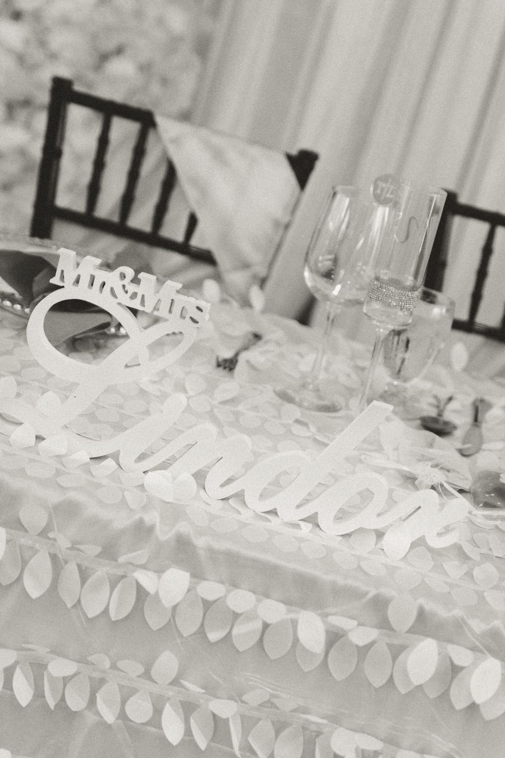 Elegant glassware and white floral decor arranged on a reception table setting.