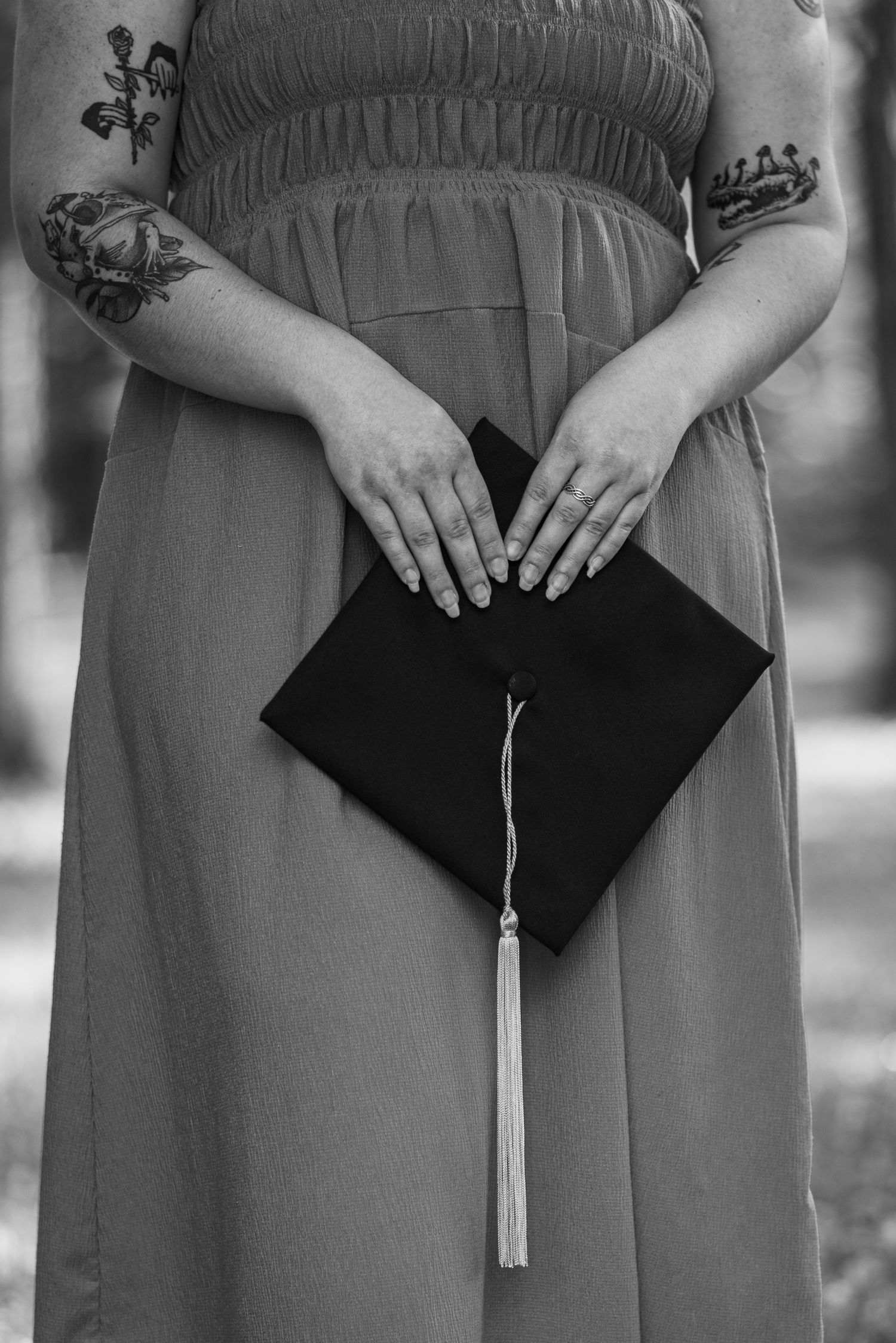 Graduates holding diplomas with tassels in black and white.