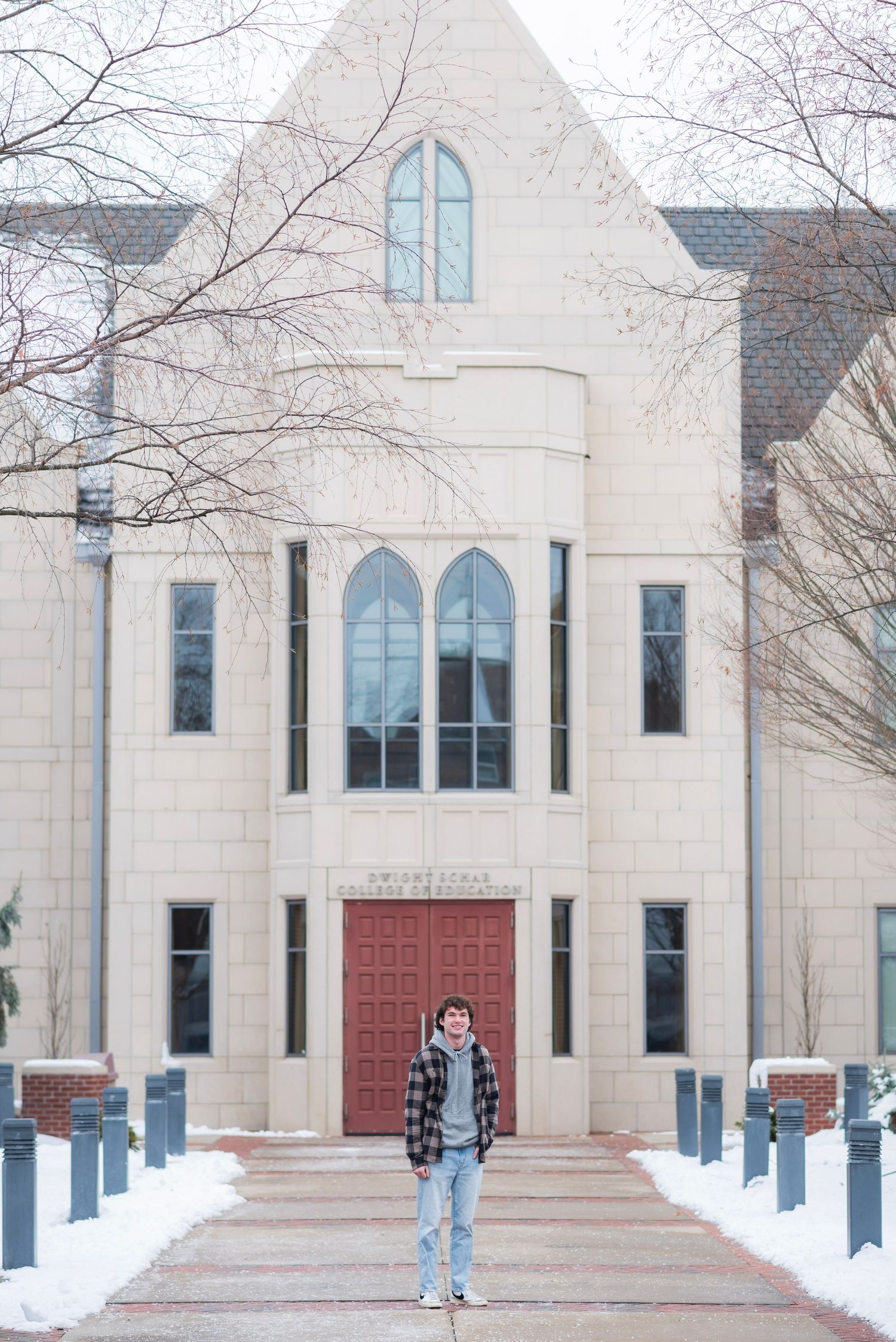 Snow-covered white stone church exterior with arched windows and red doors.