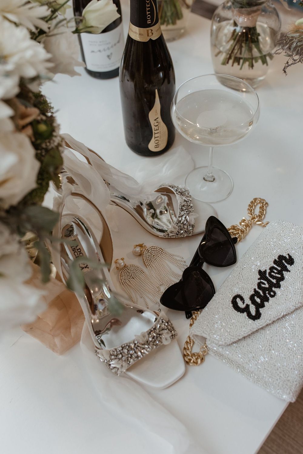 Elegant wedding decorations featuring clear glassware and delicate ribbons on a white tablecloth.