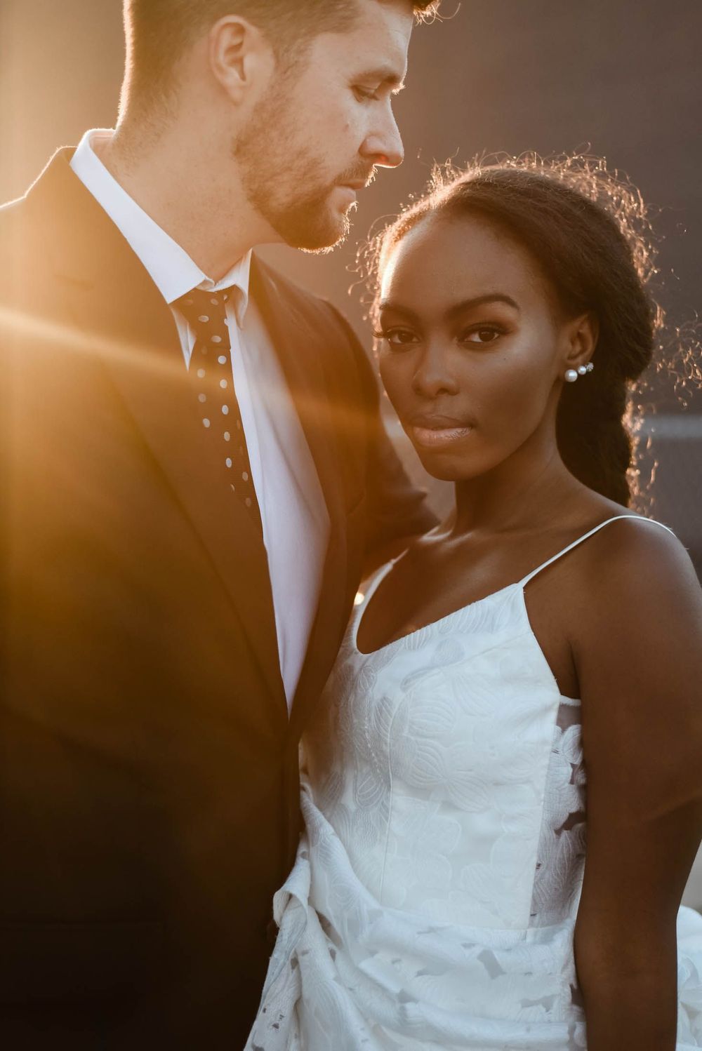 An intimate wedding portrait captures a romantic moment between newlyweds in soft golden light.