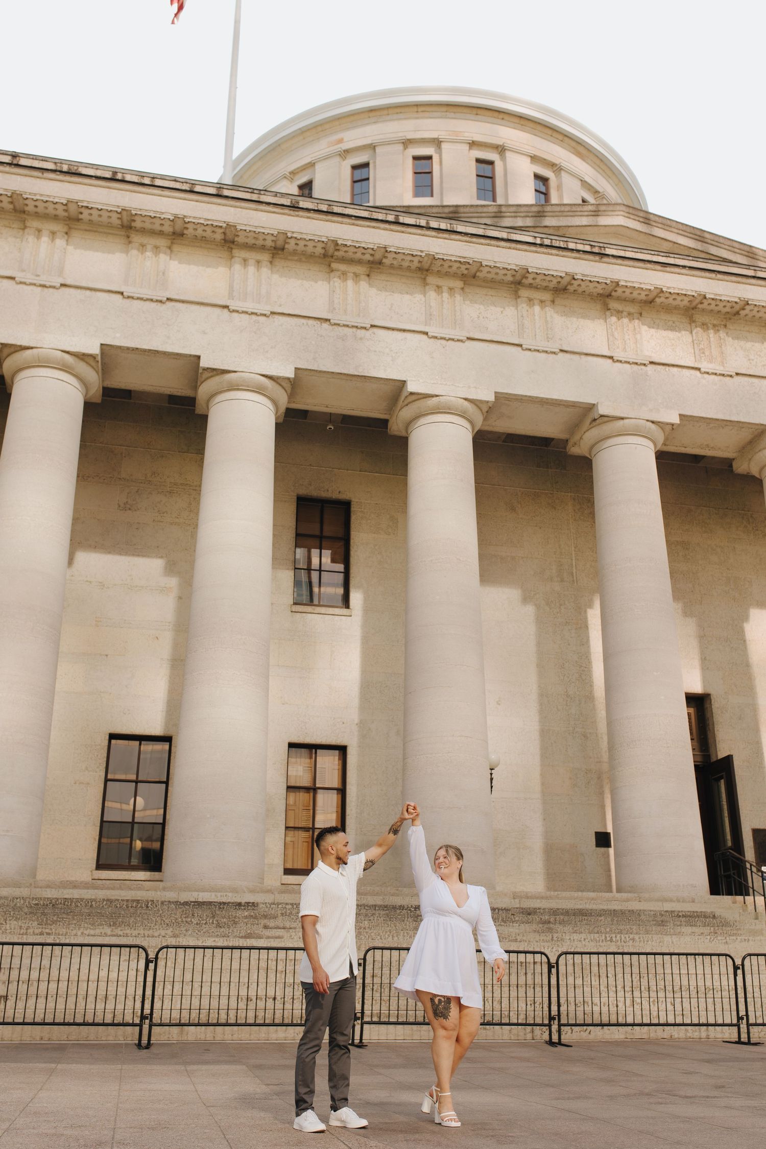 Groom-to-be spinning fiance during engagement photos in downtown Columbus, Ohio.