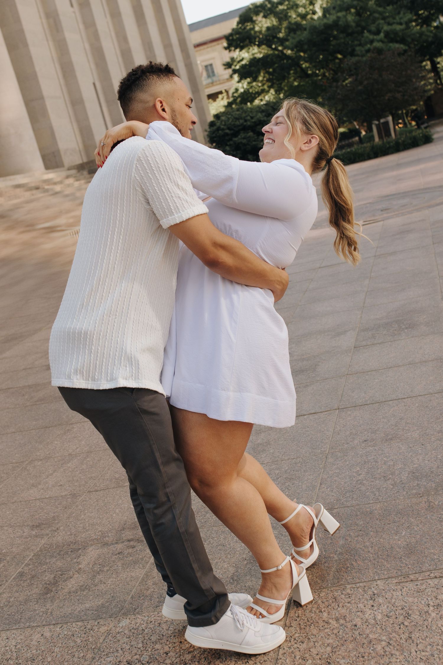The couple playfully embraces each other in front of the Ohio Statehouse in downtown Columbus.