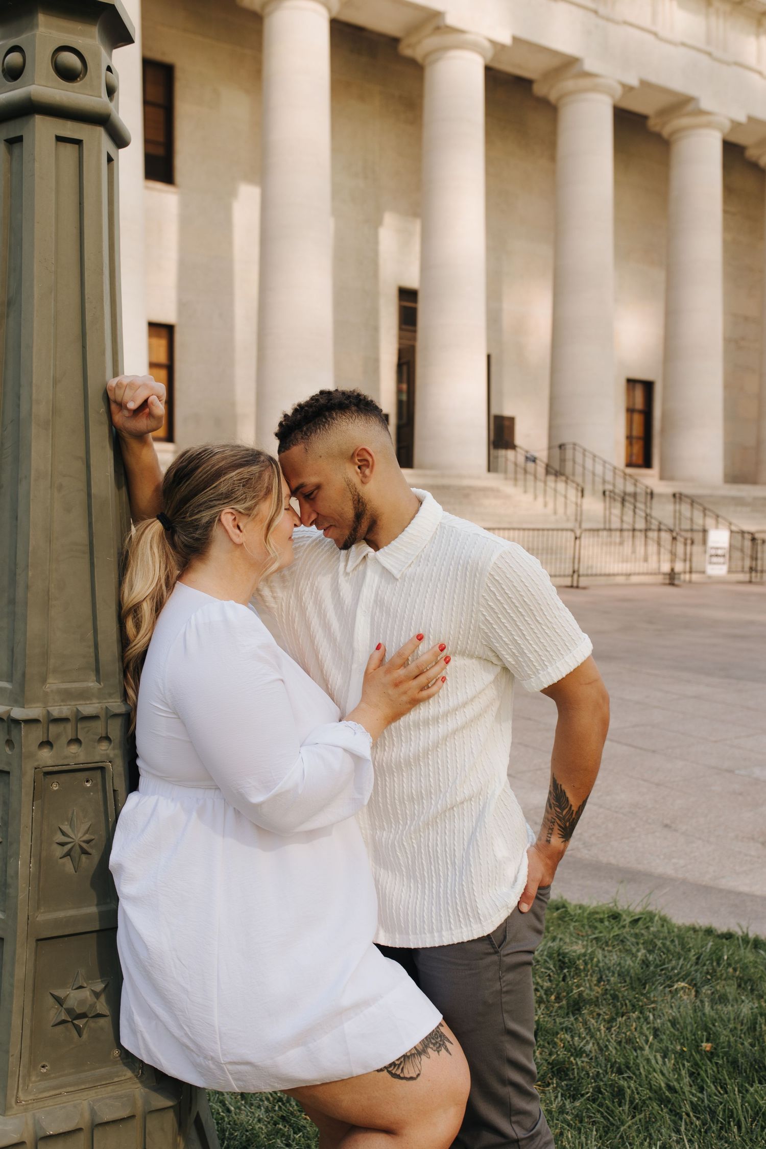 Couple leaning on lamppost during their Ohio Statehouse engagement session.