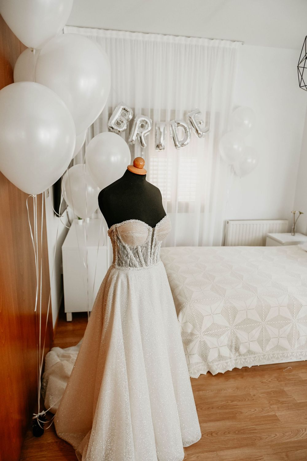 White bridal skirt and black bodice shown with party balloons and sheer curtains in an elegant room setting.