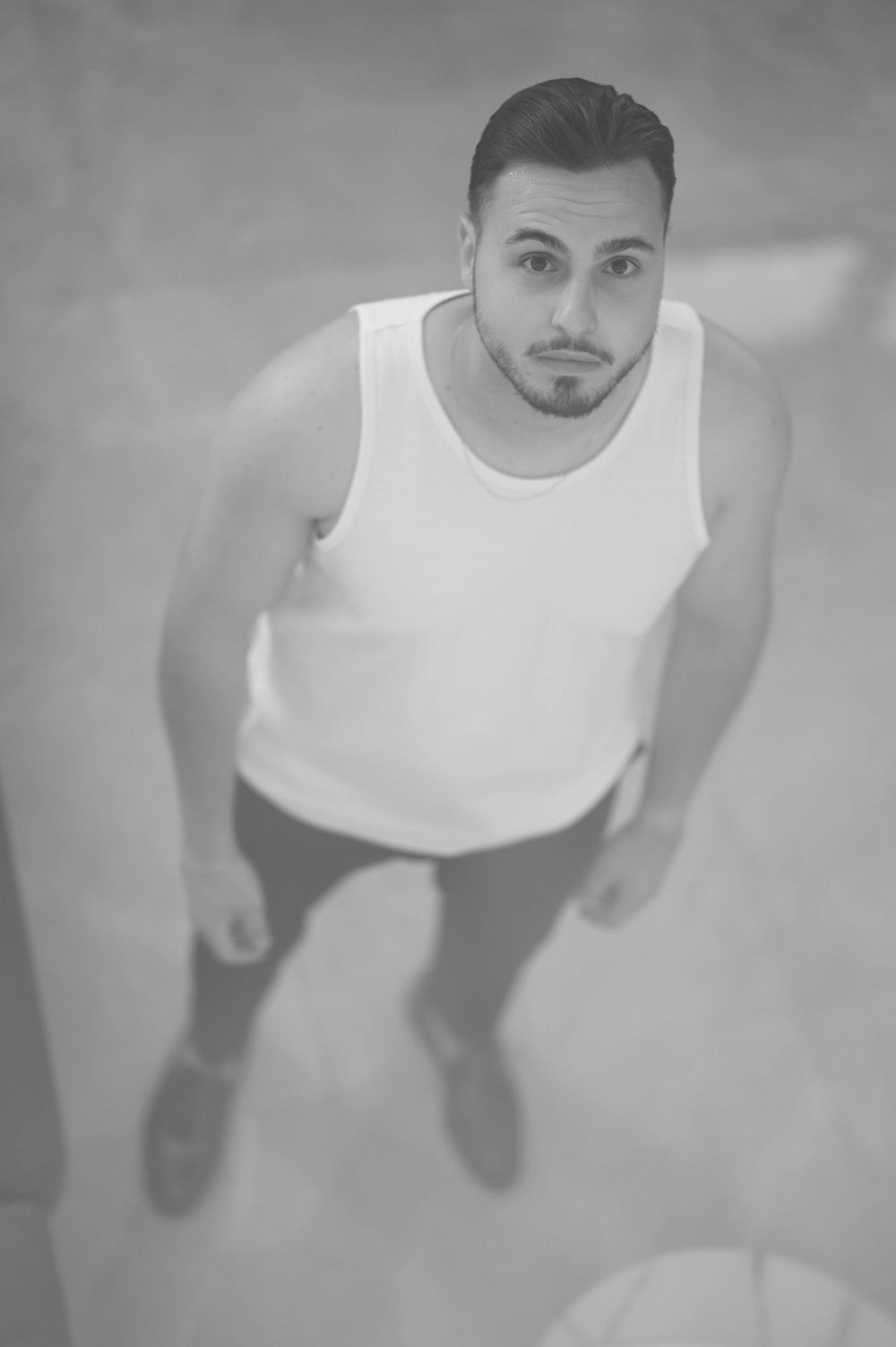 A sequential series of cropped black and white photos showing someone wearing a white tank top.
