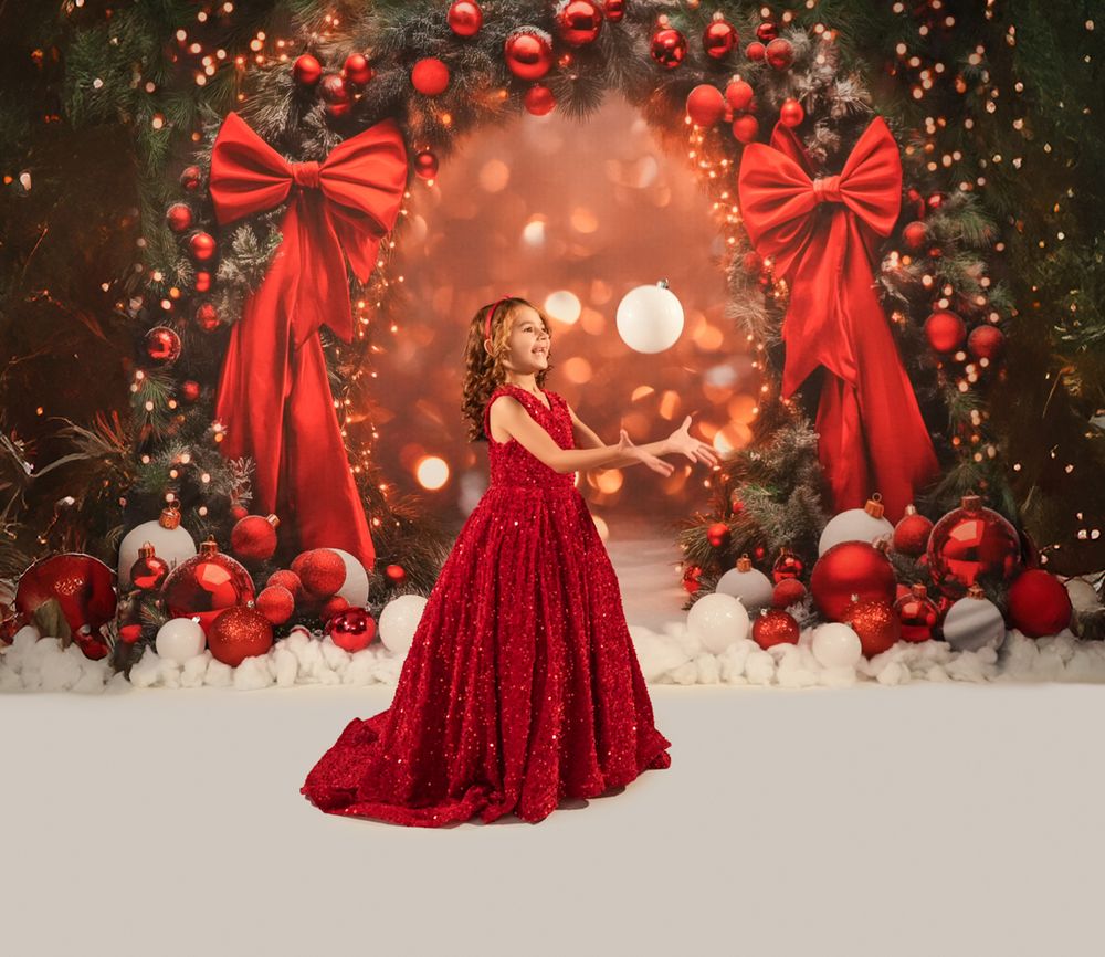 Festive Christmas backdrop with red ornaments, bows, and bokeh lights creating a magical holiday atmosphere.