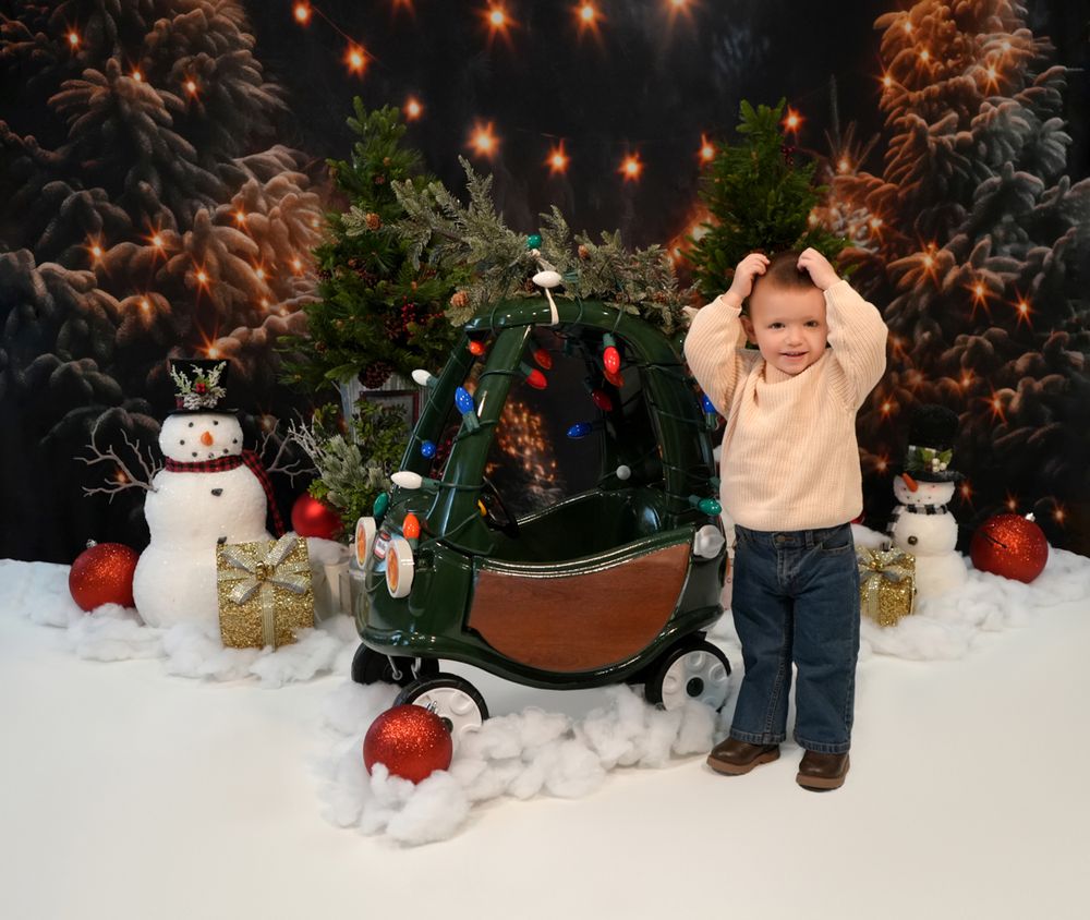 A festive holiday scene with string lights, snow, and decorative snowmen arranged against a dark background.