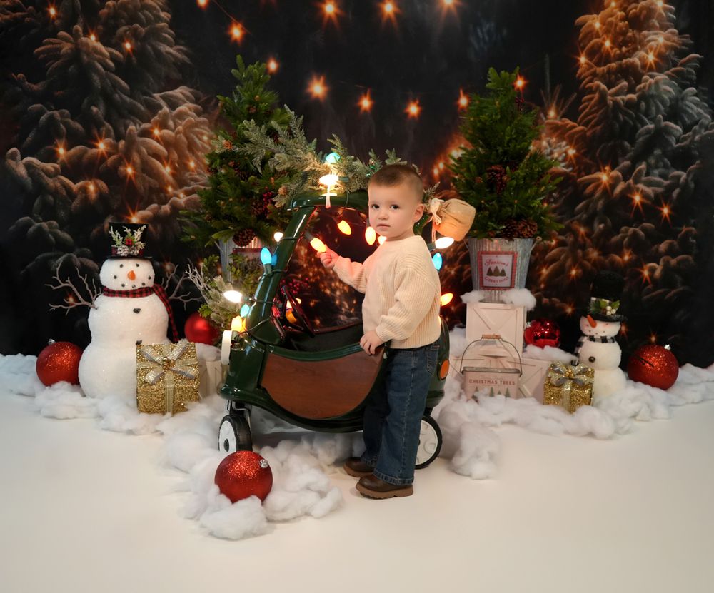 A festive winter display with snowman decorations, glowing lights, and poinsettias arranged against a white background.