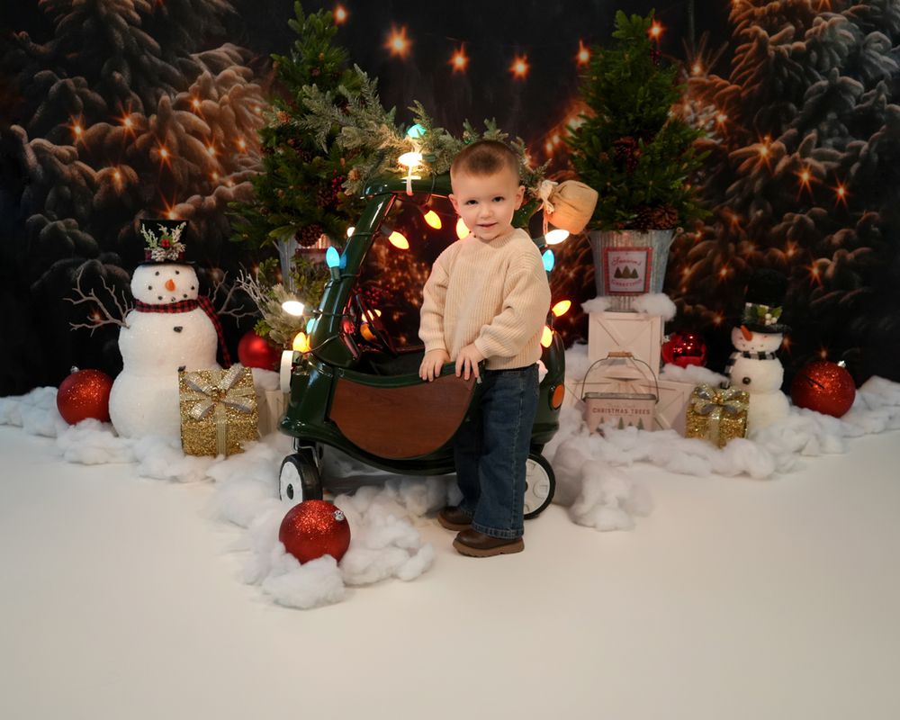 A festive Christmas display with twinkling lights, snowmen decorations, and red ornaments arranged against a snowy backdrop.