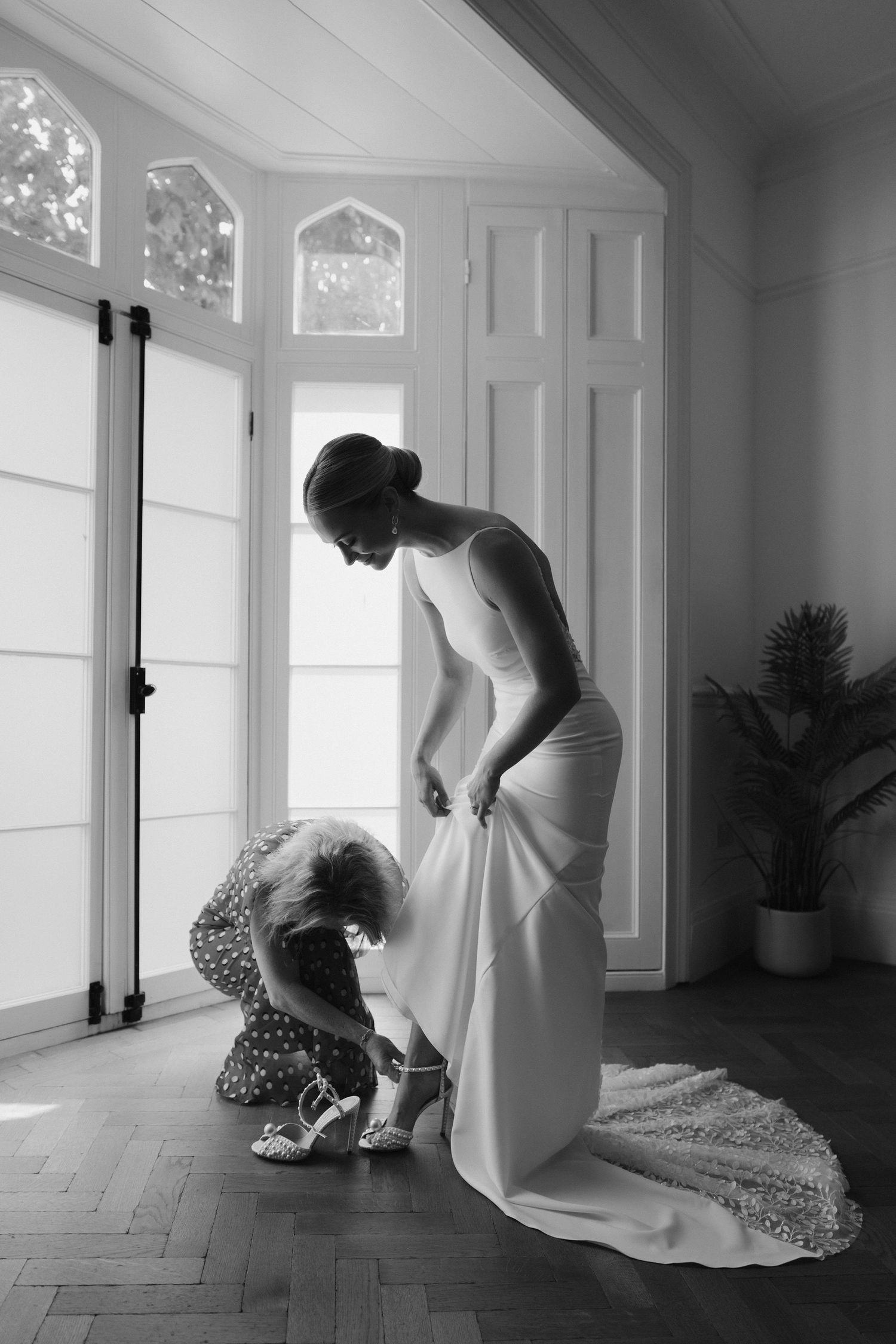 Tunnels Beach Wedding Venue in North Devon, Brides mum putting shoes on bride
