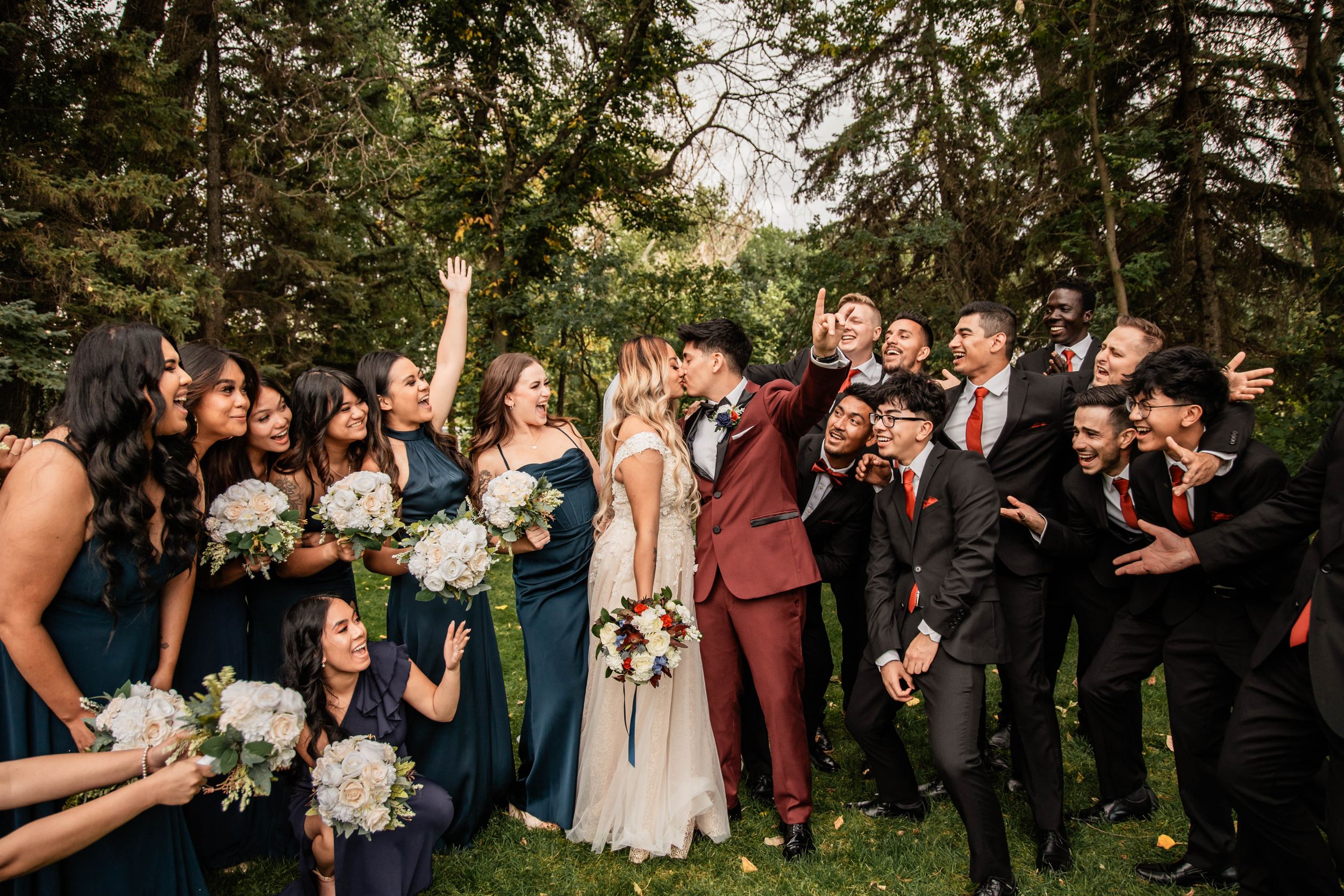 couple kissing as their bridal party cheers