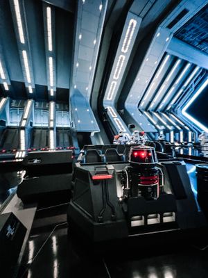 Interior view of a futuristic attraction with sleek black seats and glowing blue lighting at Disney's Star Wars: Rise of the Resistance.