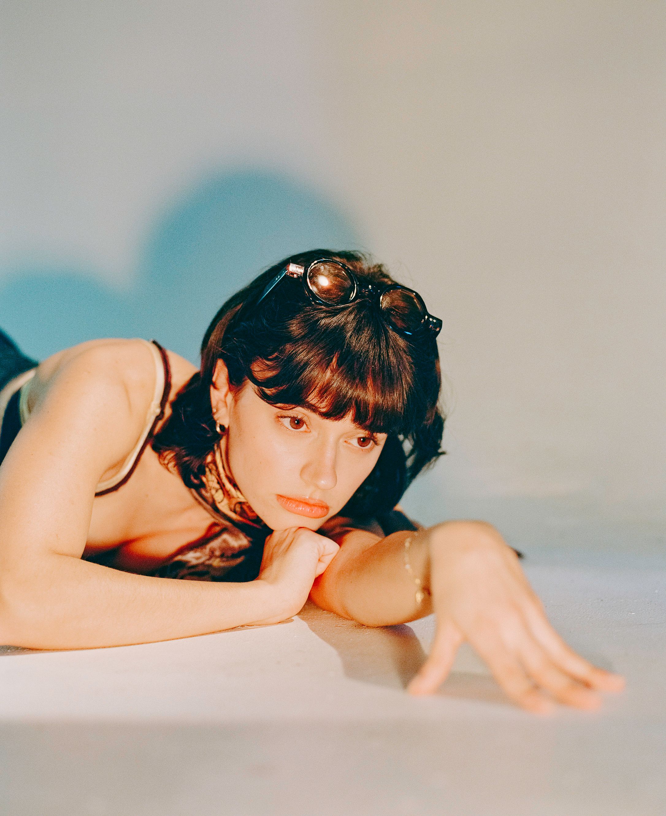 Close-up portrait with retro sunglasses and natural lighting creating a dreamy aesthetic.