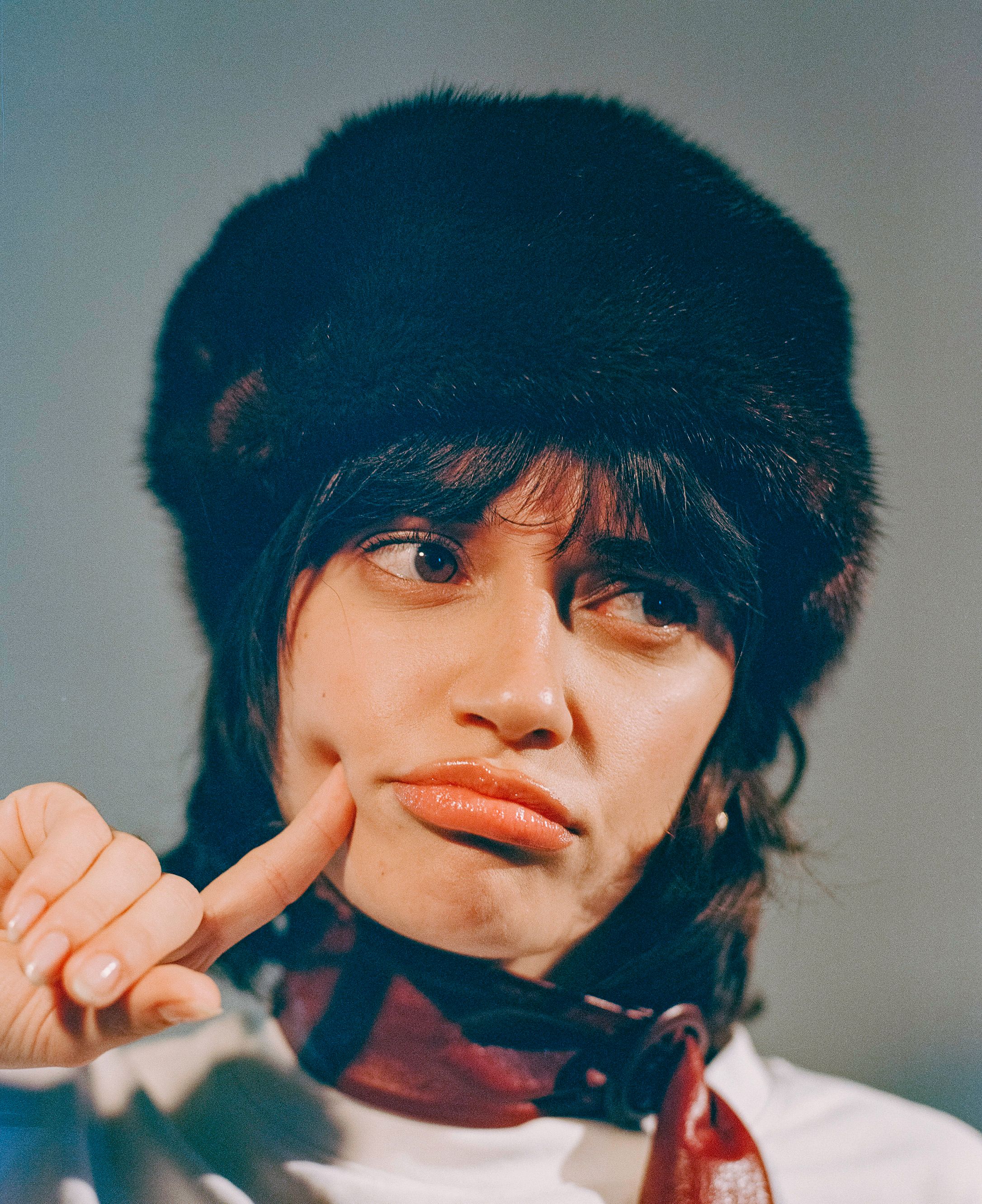 Winter fashion portrait featuring a furry hat and turtleneck in warm lighting.