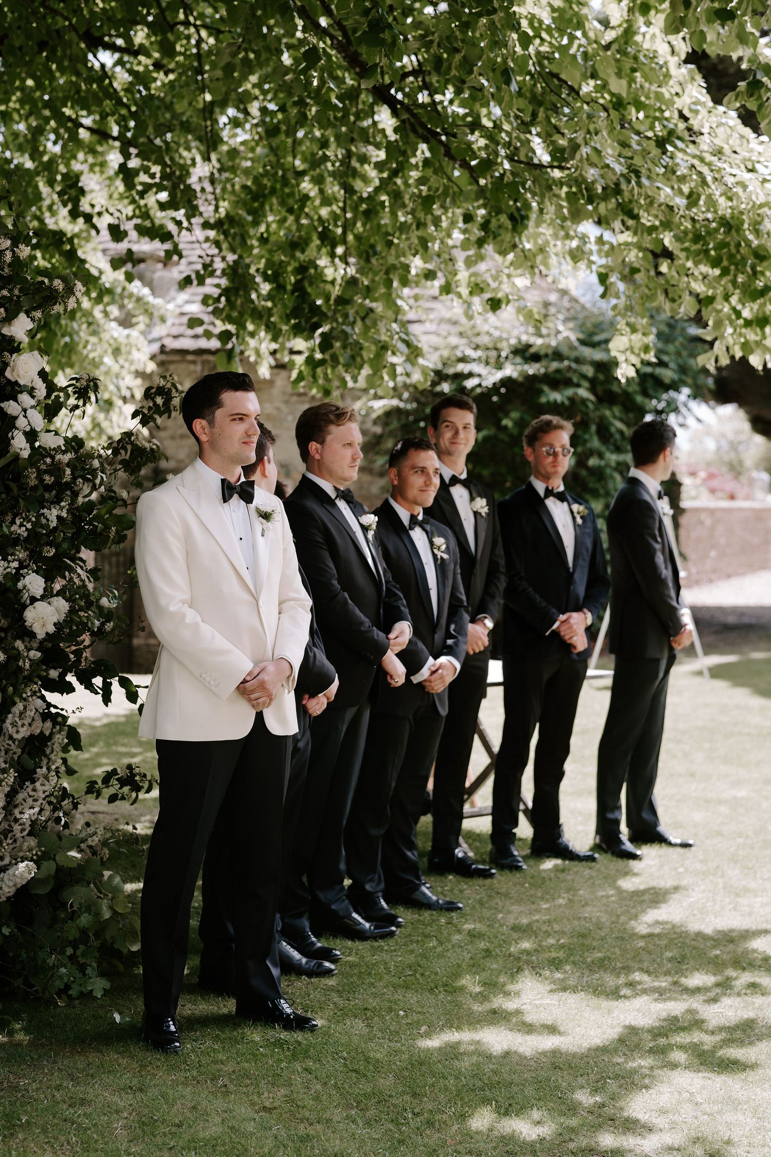 groom and groomsmen waiting at the end of the aisle at outdoor ceremony at hamswell house in bath