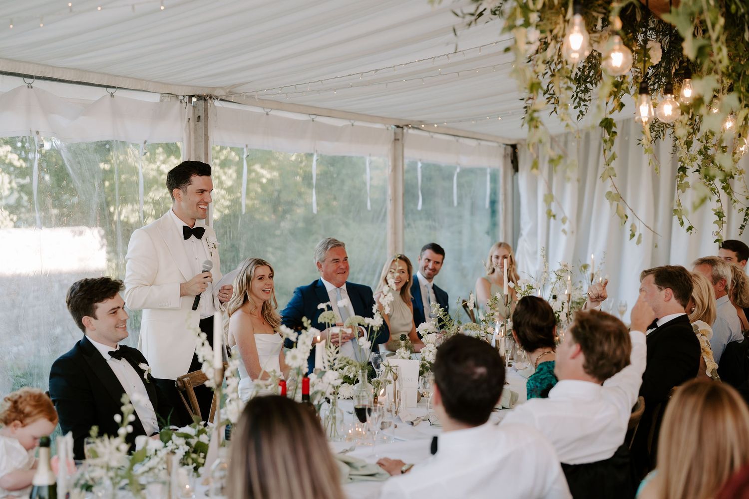 groom giving speech surrounded by guests laughing at hamswell house in bath