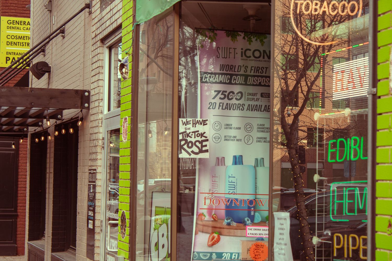 Vintage storefront with tobacco shop signs and neon lighting in an urban setting.