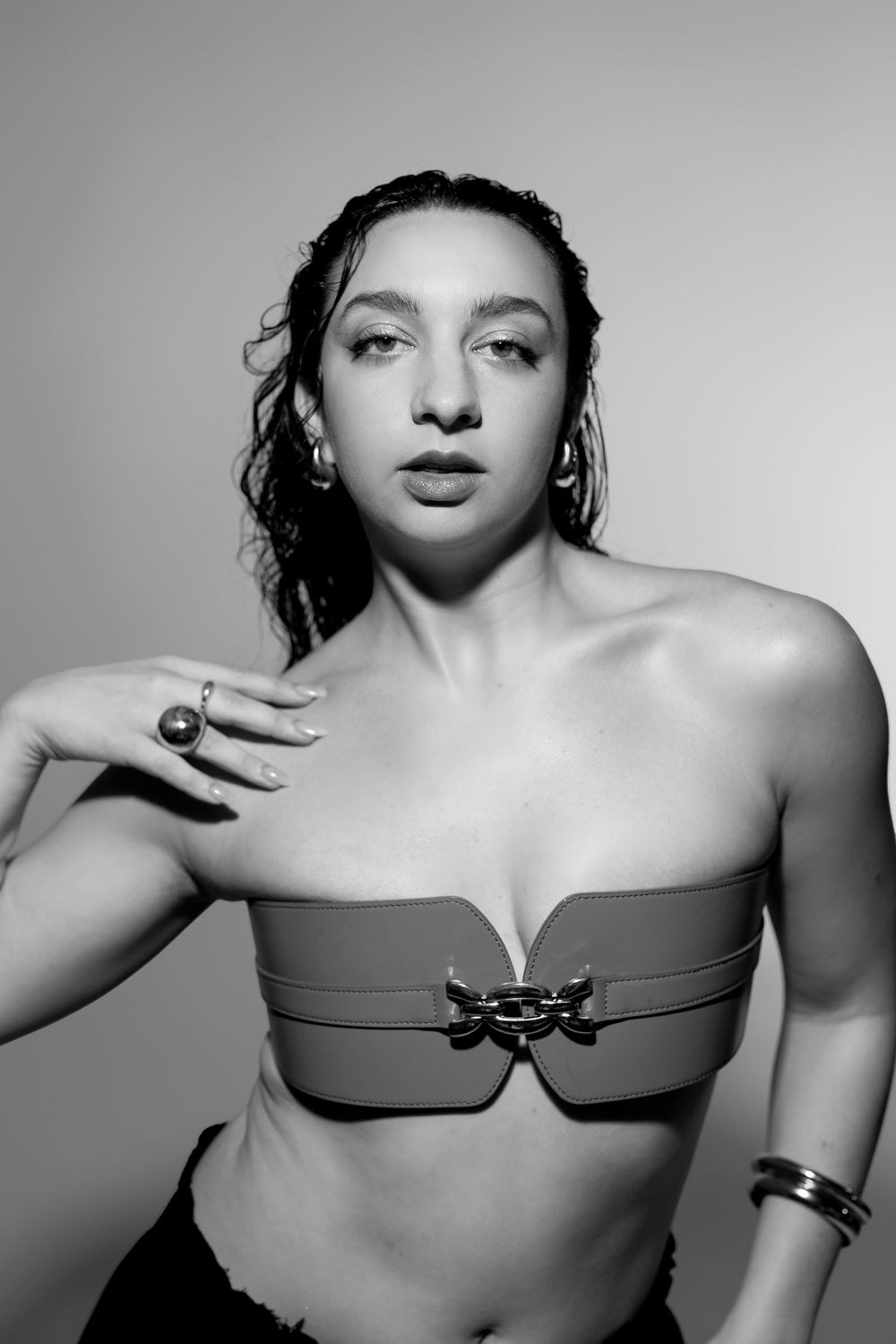 Dramatic black and white portrait in structured top with metallic detail.