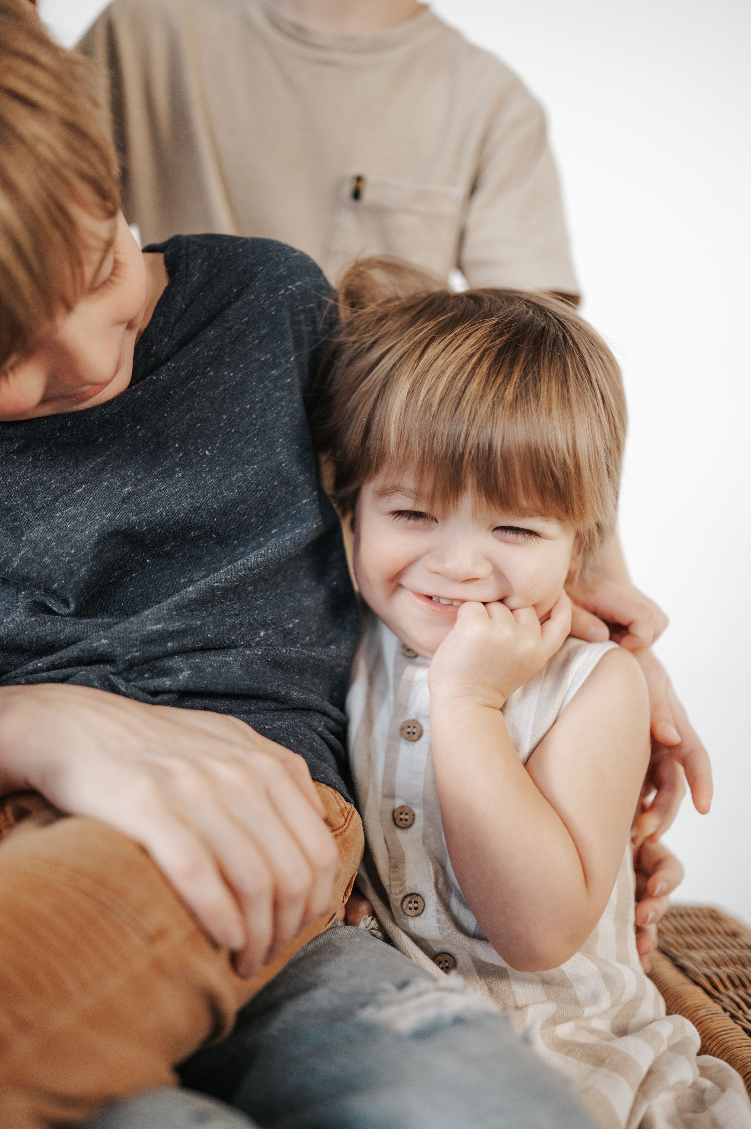 A candid lifestyle moment between a parent and child sharing laughter and affection while sitting together.