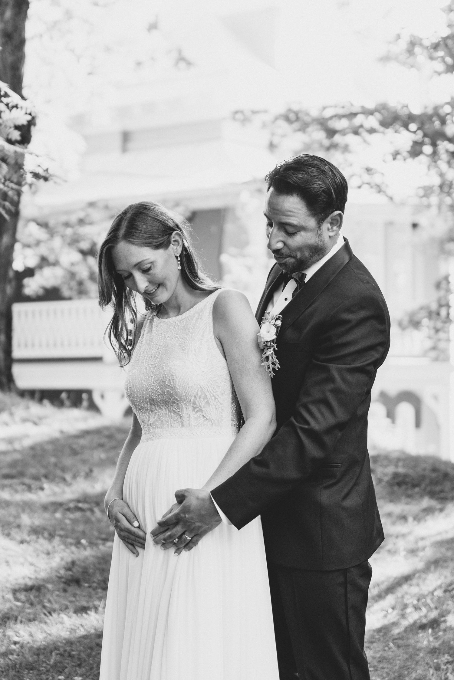 A tender black and white wedding portrait of a couple sharing an intimate moment outdoors.