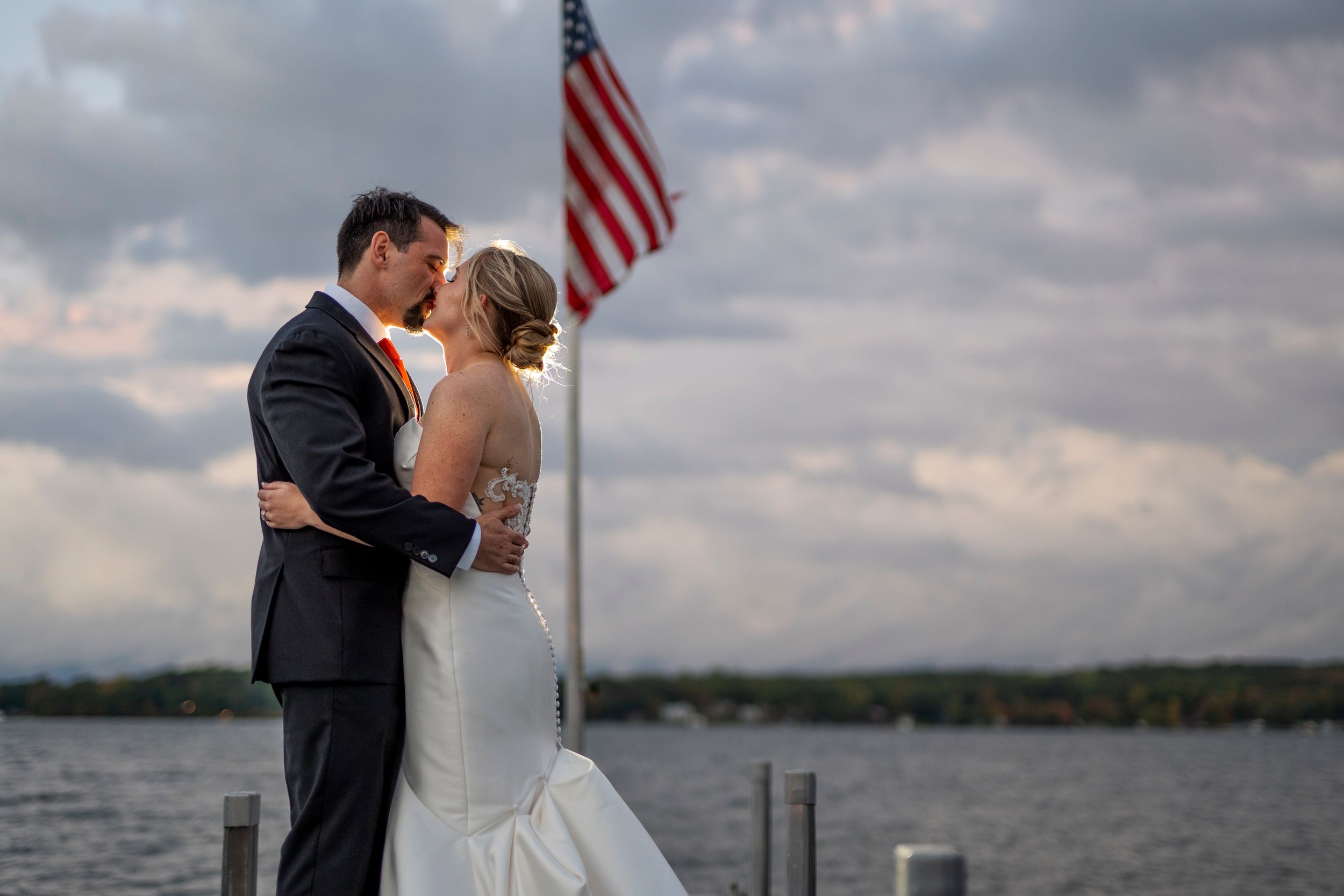 A romantic sunset moment on a dock with an American flag in the background.