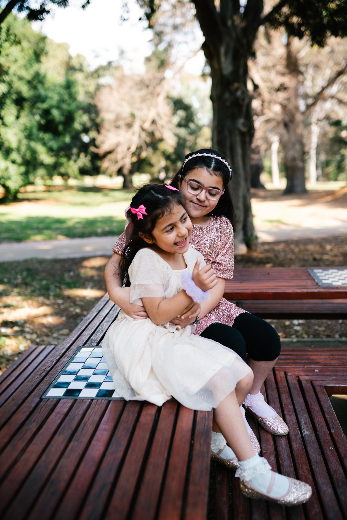 2 sisters having fun in a Melbourne family photoshoot session in St Kilda botanical gardens taken by a Melbourne family photographer