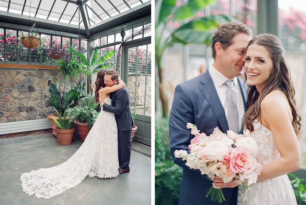 Romantic wedding couple embracing in conservatory garden with lace dress and floral bouquet.