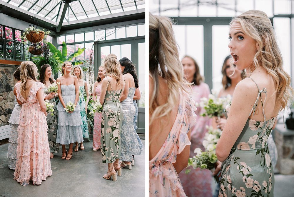 Bridesmaids in floral and pastel dresses celebrate at an elegant greenhouse wedding venue with natural lighting.