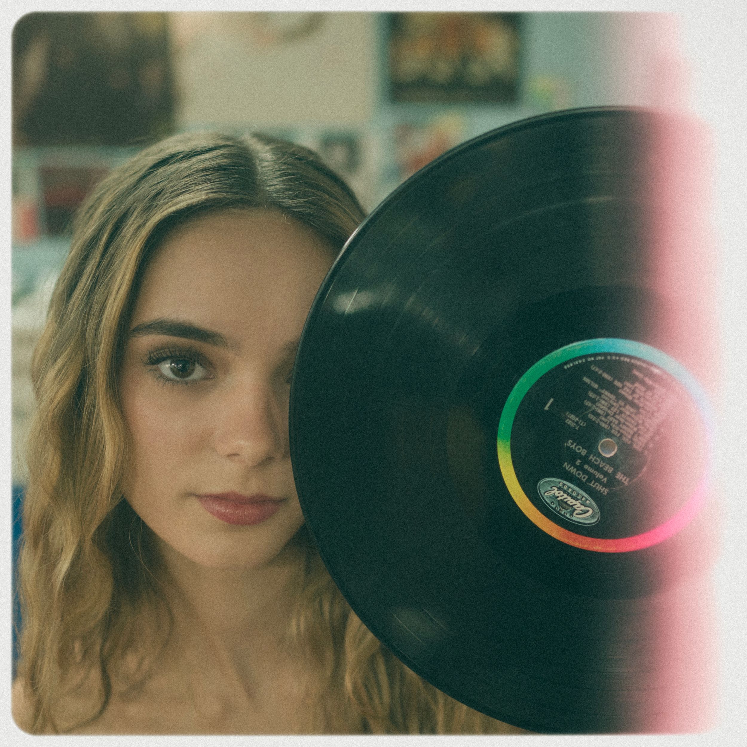 Vintage-style portrait with person holding a vinyl record.