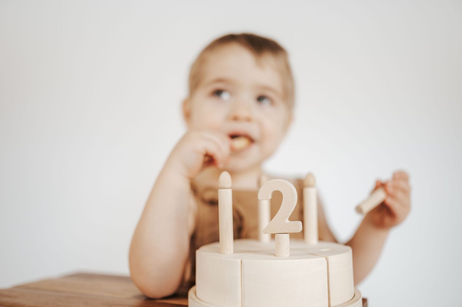 A wooden number 21 display with candles sits on a table while a figure appears blurred in the background.
