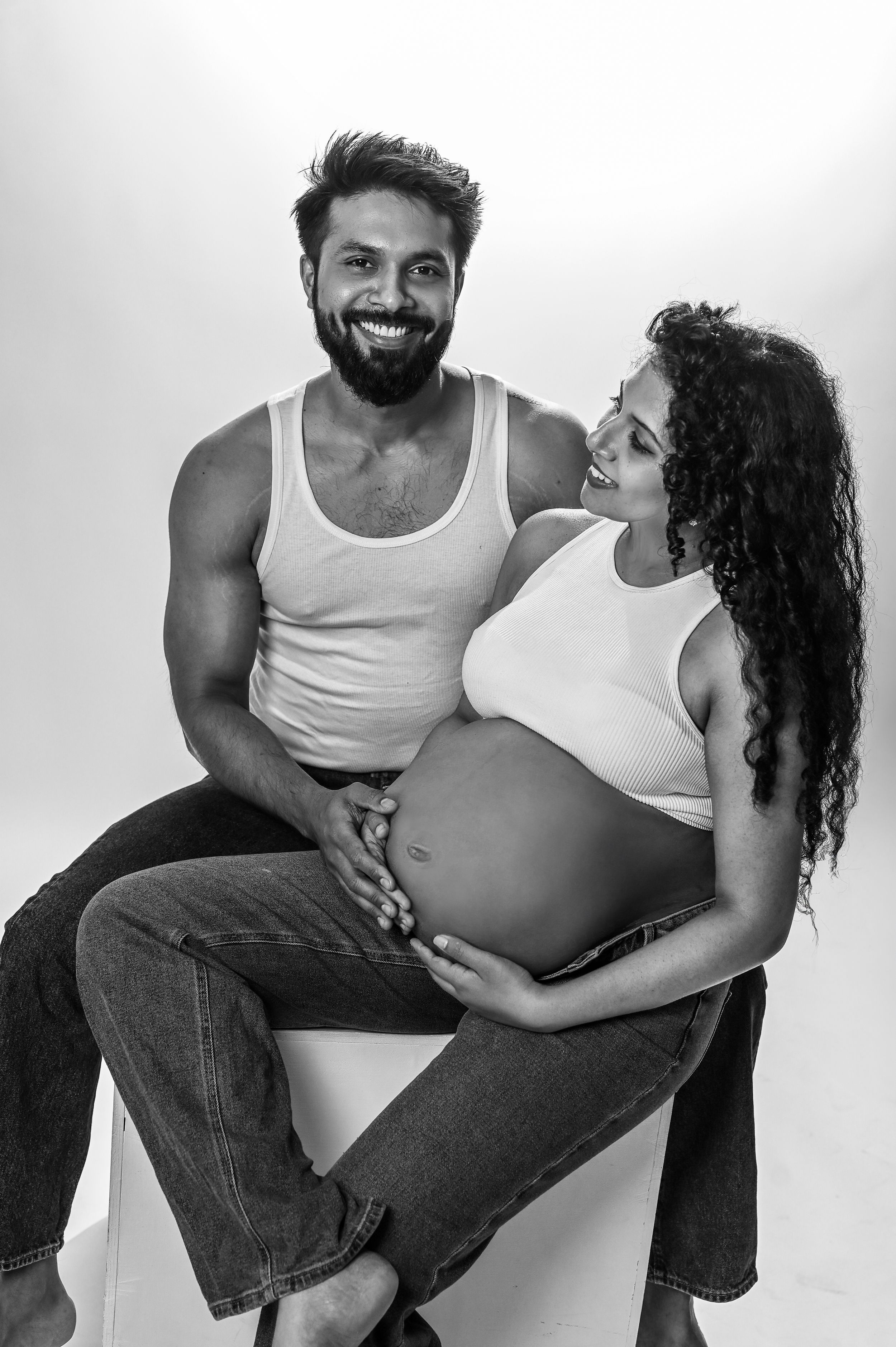 Black and white maternity photo of couple sharing tender moment.