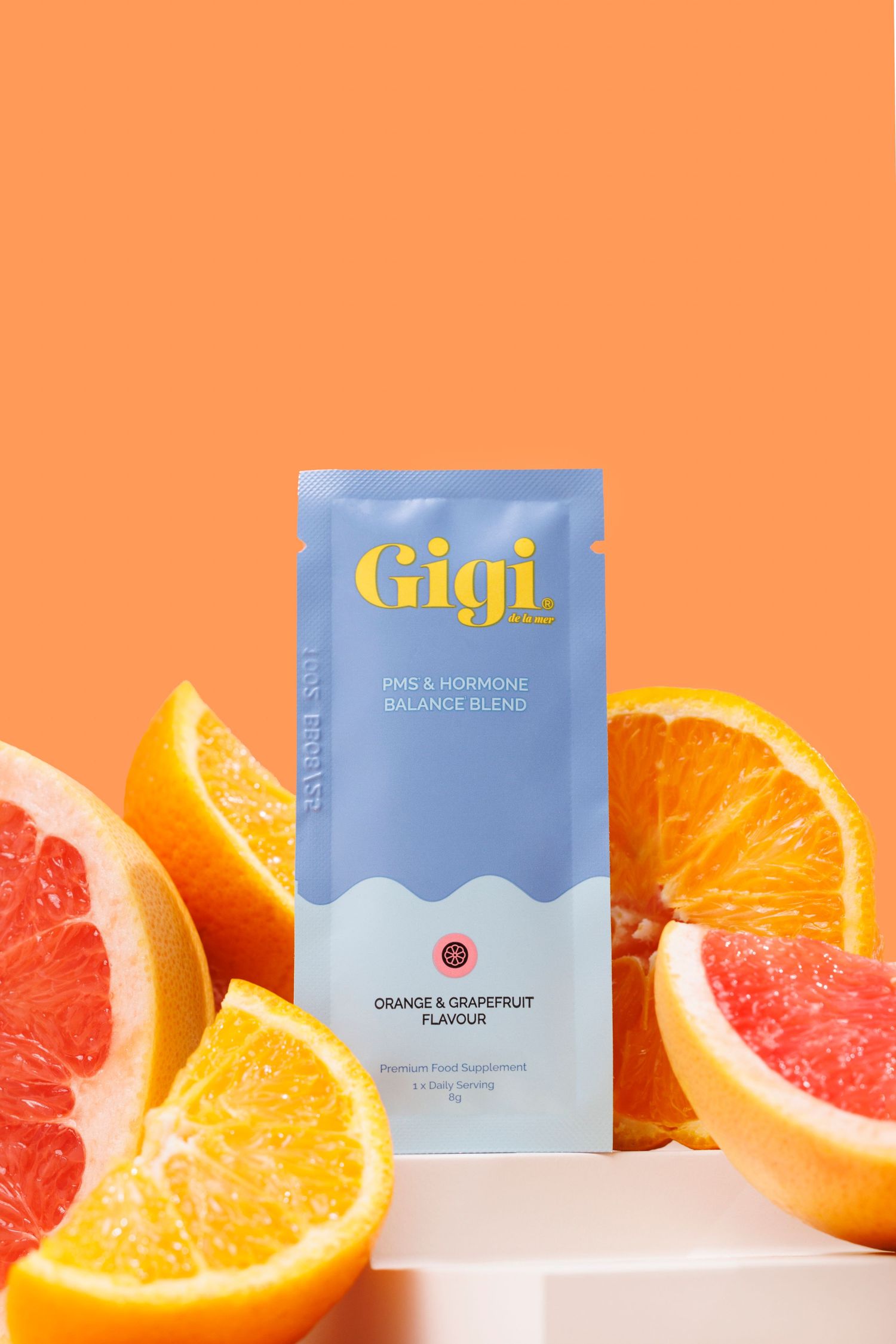 Hero image of Gigi drink mix packet with citrus flavouring displayed alongside fresh orange and grapefruit slices on orange background.