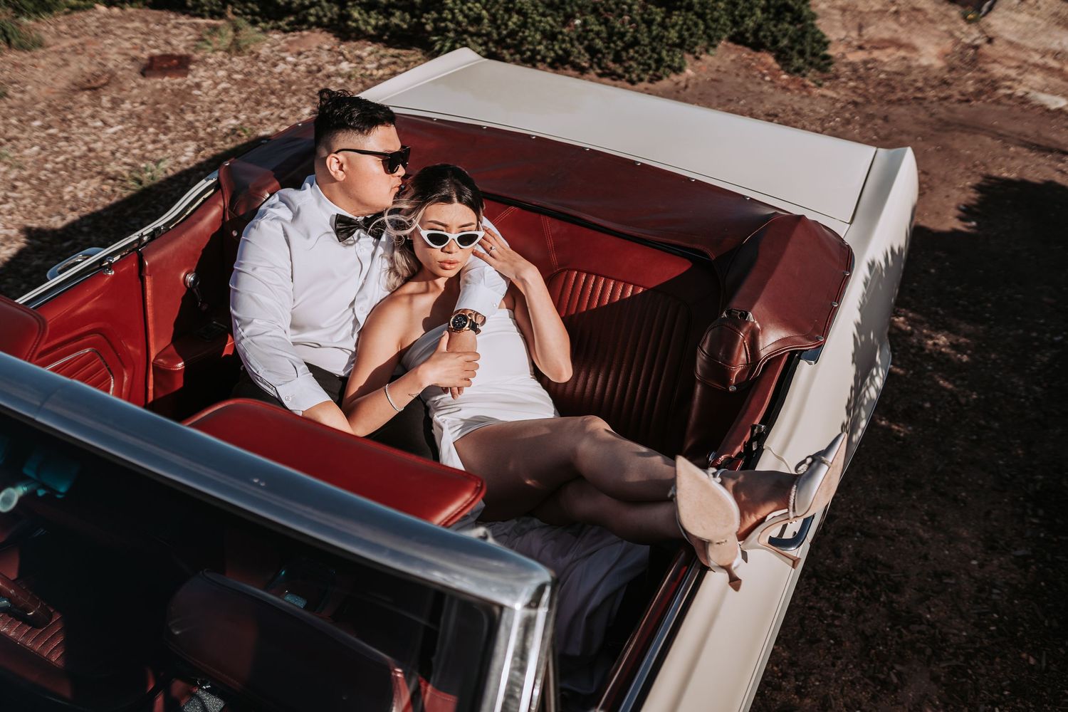 Retro-styled photoshoot in classic car with red leather interior.