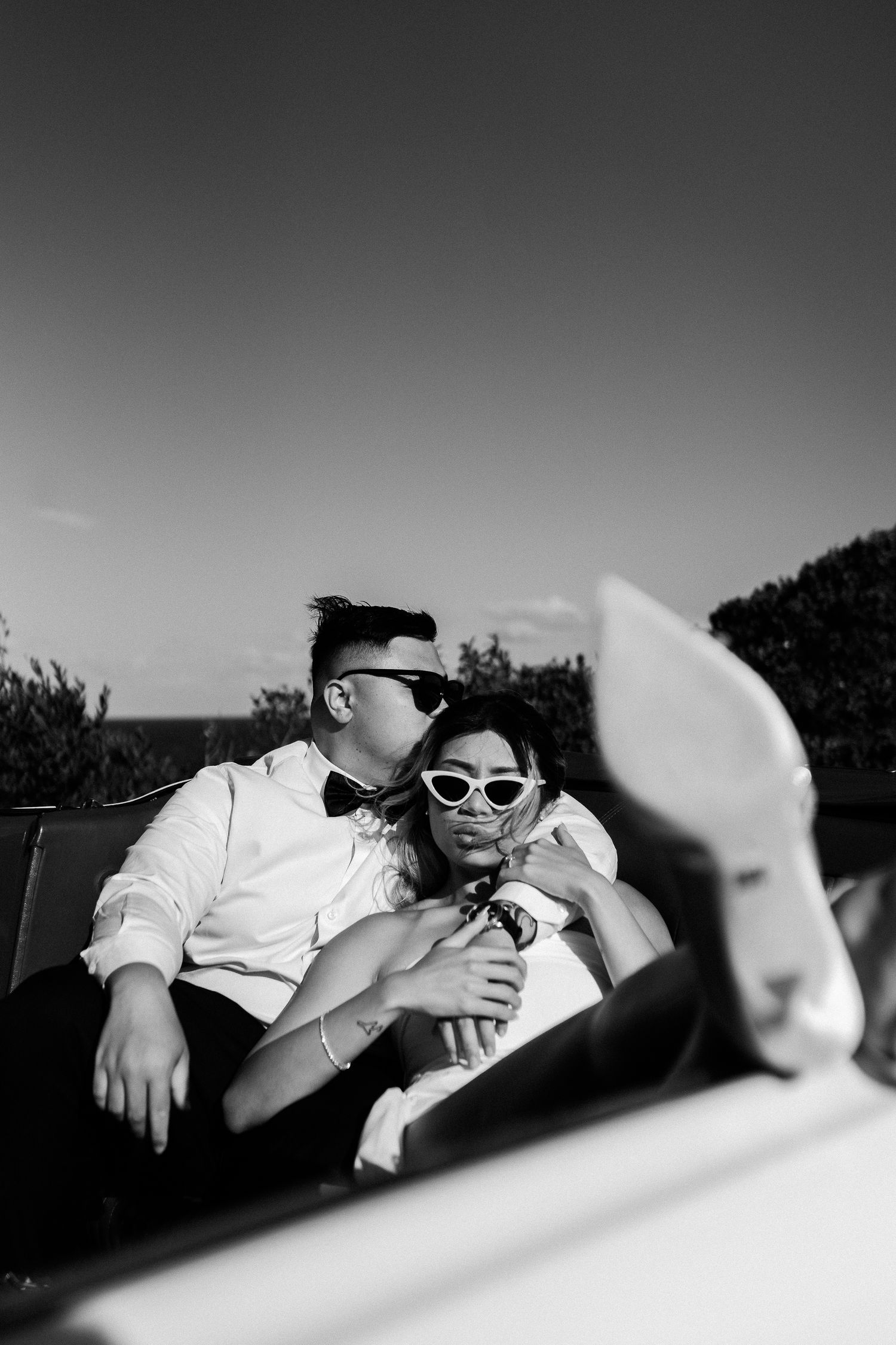 Black and white vintage car photoshoot with retro sunglasses style.