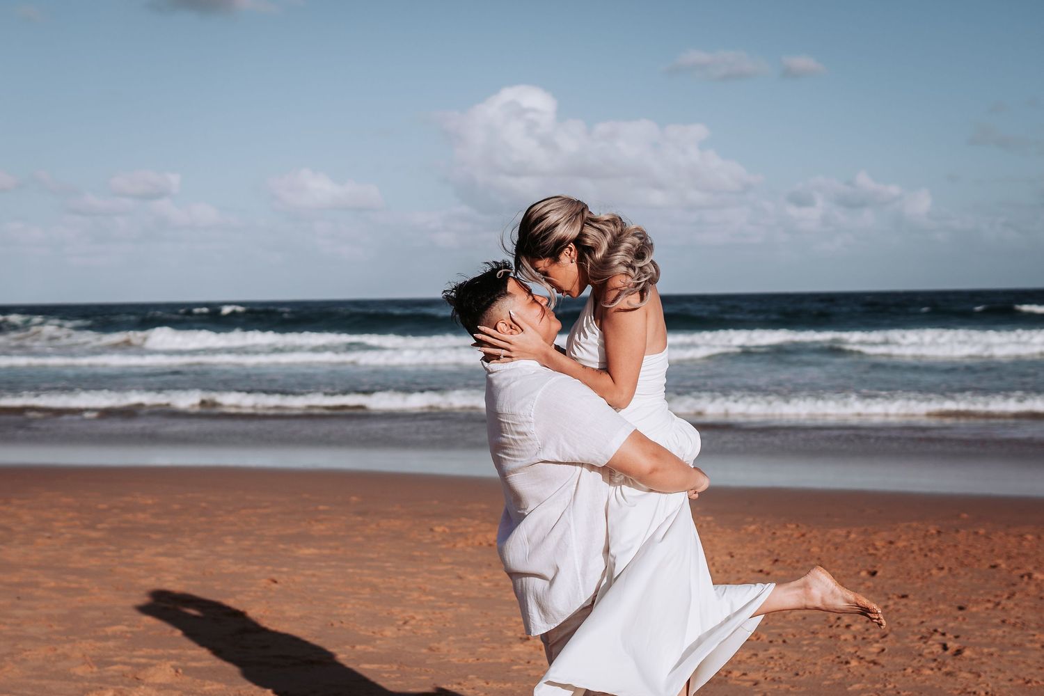 A romantic moment shared between two people embracing on a sunny beach.