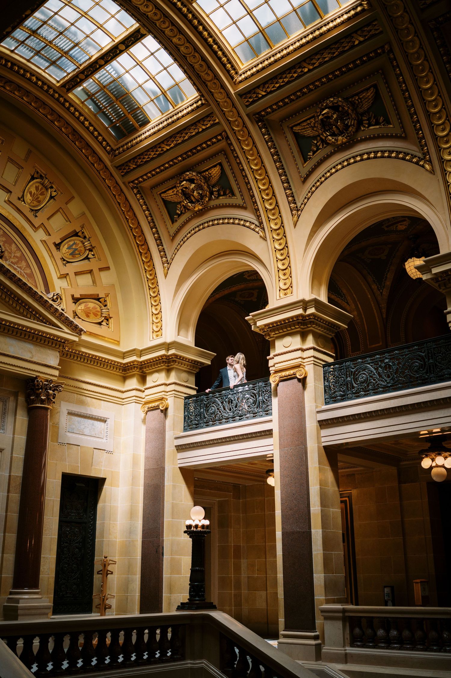 Grand interior architecture with ornate arches, skylights and decorative moldings in a classical Beaux-Arts building.