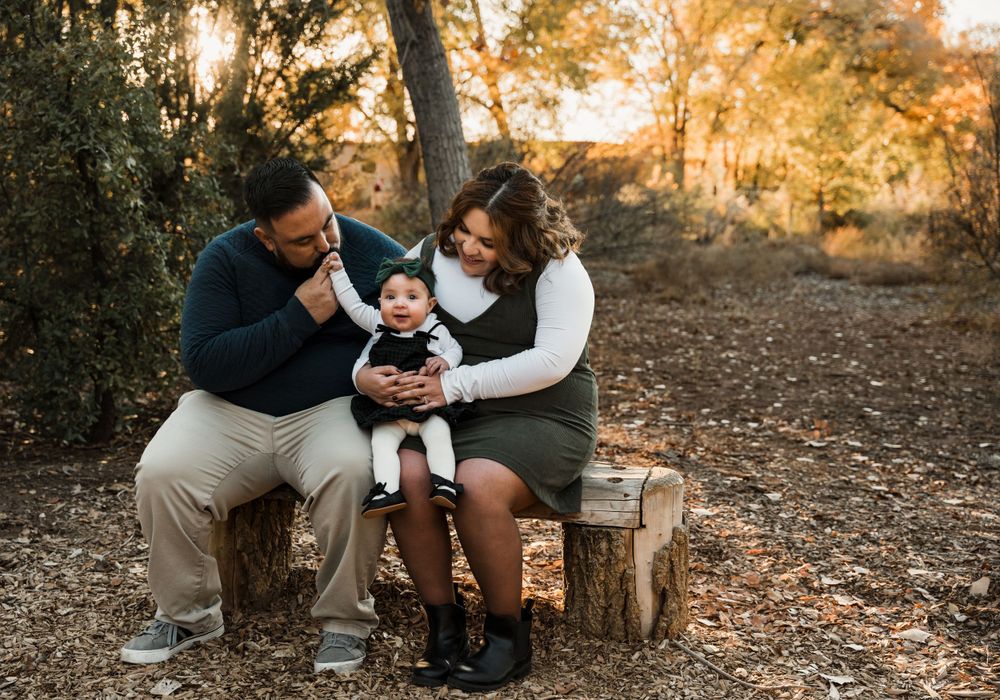 Candid family moments photographed in a serene woodland setting at sunset.