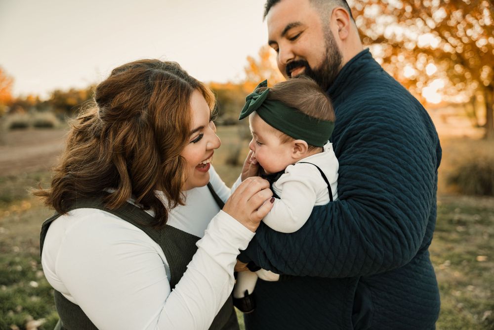 Warm and intimate family portraits taken during golden hour in a forest setting.