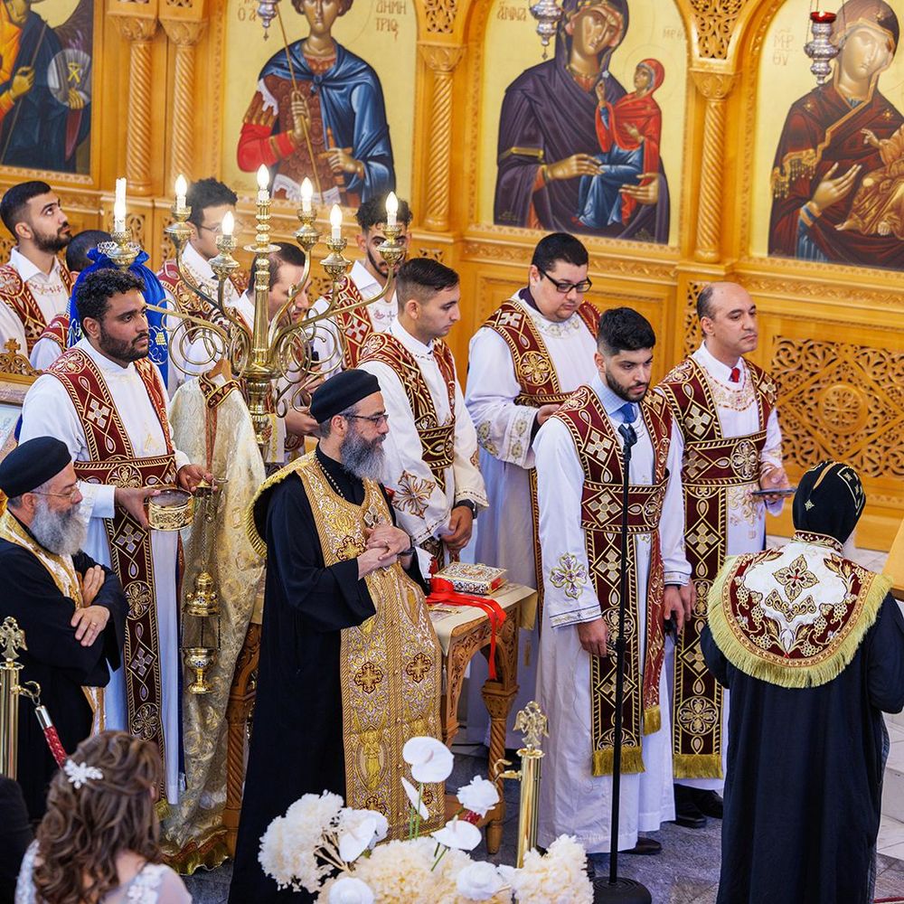 Coptic Orthodox clergy and deacons gathered at altar during elaborate wedding ceremony.