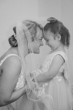 Bride forehead to forehead with flower girl.