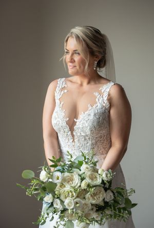 Bride looking out window holding bouquet