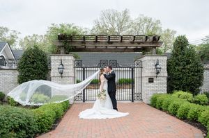 Bride and Groom kissing, with brides veil in the wind.