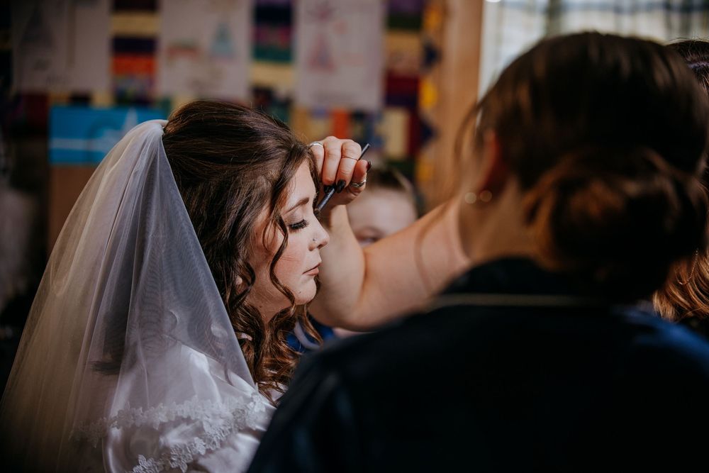 A romantic kiss between newlyweds during their wedding ceremony, with the bride wearing a white veil.